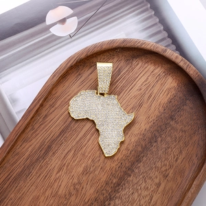Iced out gold Africa map pendant necklace with shimmering crystals on wooden tray