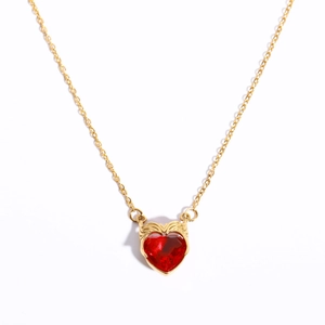 Golden necklace featuring a red heart zircon pendant with winged crown detail on white background