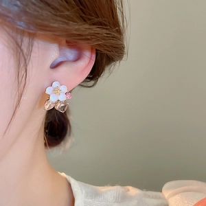 Macro shot of elegant floral earrings with pearls and crystals on a model's ear