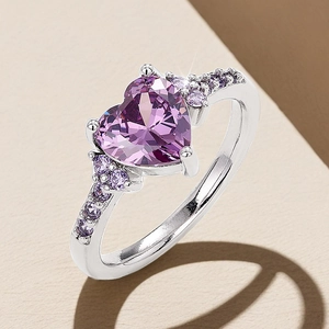 Detailed close-up of an elegant silver ring featuring a purple heart-shaped gemstone