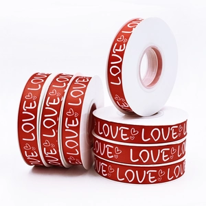 Red ribbon rolls with white LOVE print and heart patterns for Valentine gift wrapping