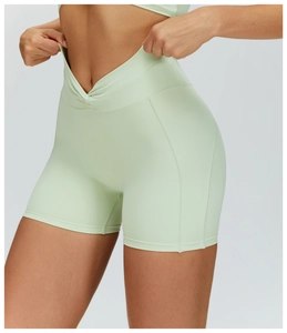 Dettaglio dei pantaloncini da yoga a vita alta con nodo a incrocio in verde menta