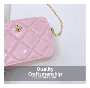 Detail of pink jelly bag showing quilted texture and golden camellia flower clasp