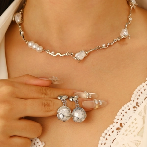 Baroque pearl jewelry set close-up with necklace and ring on a lace blouse model