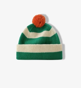 Detail of green and beige striped knit beanie featuring a vibrant orange pom-pom top