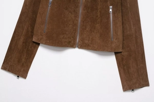 Vue détaillée d'une veste en daim marron montrant la fermeture éclair et les poignets