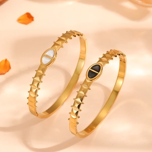 Detail of gold-plated titanium steel bangles with serrated edges and oval drip oil design.