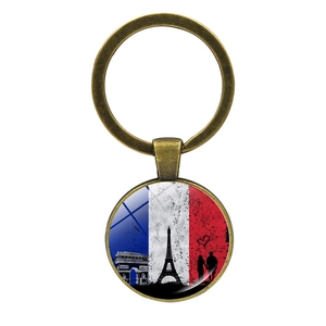 Detalle de llavero vintage de bandera francesa con torre Eiffel y arco de triunfo