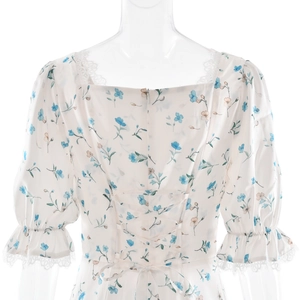 Detail of square neckline with white lace trim and blue floral satin dress pattern