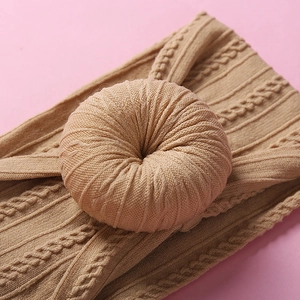 Soft nylon camel baby headband featuring a large knitted donut floral decorative knot