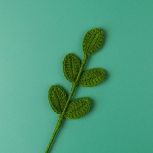 Detailed view of handmade crochet green leaf branch with intricate knit texture and 5 leaves