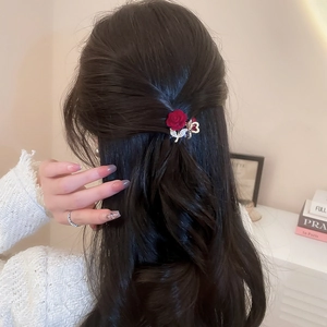 Detailed view of red velvet rose hair claw with sparkling rhinestone butterfly design