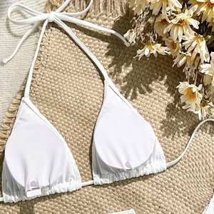 Innenansicht des weißen Bikini-Oberteils mit herausnehmbaren Pads auf Strohmatte