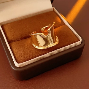 Macro detail of a wide wavy gold ring with polished finish in a velvet jewelry box