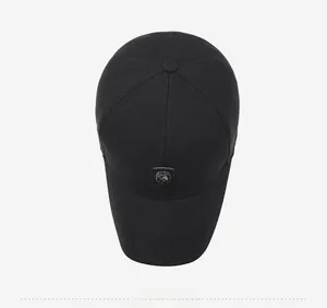 Top view of a black baseball cap showing woven texture and metal shield logo detail