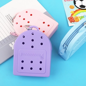 Pink, purple and blue mini silicone bags with DIY holes on a clean blue background