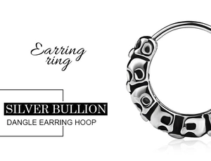 Macro shot of silver punk earring hoop with vintage black engraved patterns and textures