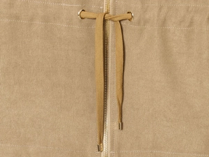Detail of khaki jacket showing gold metal zipper and drawstring with metal aglets