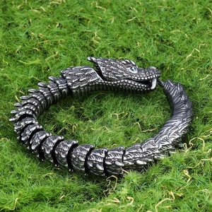 Gothic 3D snake bracelet in antique silver finish with green eyes on green grass