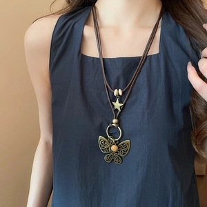 Detail of vintage butterfly pendant necklace with wooden beads on long wax cord