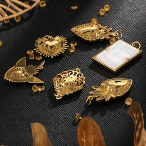 Golden heart pendants with crown wings and zircon accents on a textured background