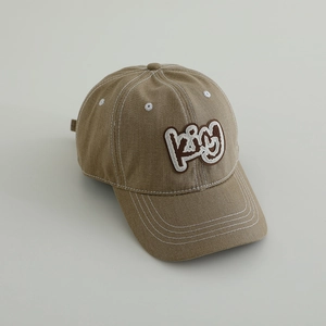 Detail of 3D embroidered KING text on vintage washed denim kids baseball cap