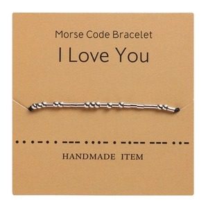 Detail of Morse code bracelet on kraft card showing I Love You symbol with beads