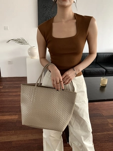 Detailed view of large straw tote bag featuring intricate woven texture and beige finish