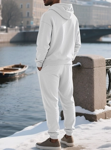 Outdoor view of men's knit tracksuit set with textured jacquard fabric in light grey