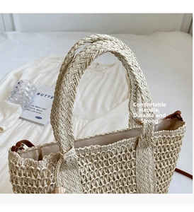 Detailed top view of a woven straw tote bag with sturdy handles and internal lining