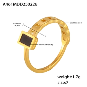 Macro detail of golden chain ring with black shell inlay and size specifications