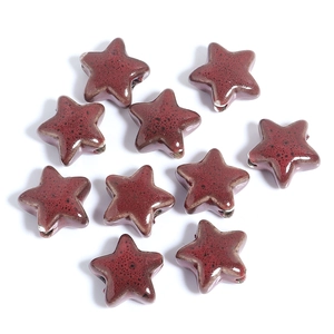 Detailed view of red ceramic star-shaped beads with vintage speckled glazed texture
