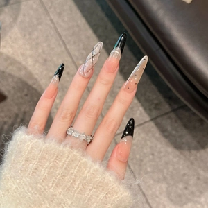 Detailansicht langer Stiletto-Nägel zum Aufkleben mit schwarzen French-Tips und Linien