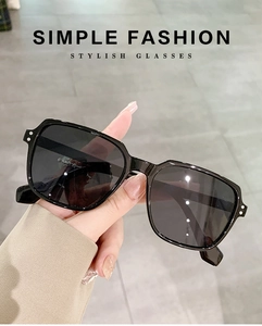 Detail of black oversized square sunglasses featuring stylish metal stud accents