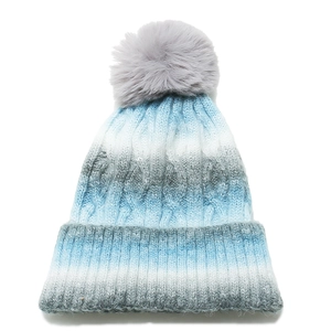 Detail of thick knit gradient beanie with large fluffy grey faux fur pom pom top
