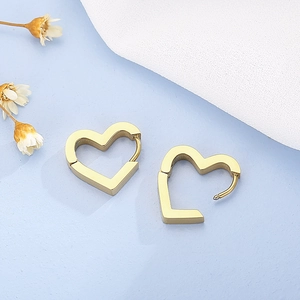 Detailed close-up of golden heart-shaped hoop earrings on elegant floral background