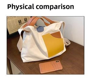 Detail view of large white canvas tote bag with contrast yellow leather pocket on desk