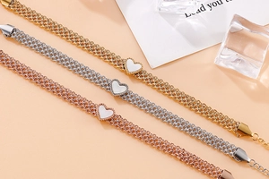 Macro shot of multi-layer heart charm bracelets in gold, silver and rose gold finishes