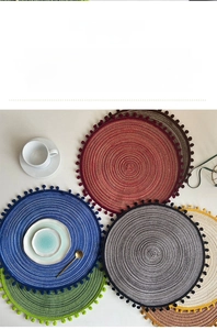 Detail view of woven coasters with spiral texture and playful decorative pom-pom edges