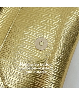 Détail du cuir doré à texture ondulée et du fermoir magnétique rond en argent
