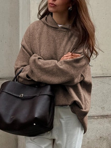 Close-up of brown knitted hooded sweatshirt featuring soft fabric and a loose fit