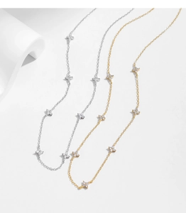 Detailed view of layered S925 sterling silver necklaces in gold and silver with flower charms