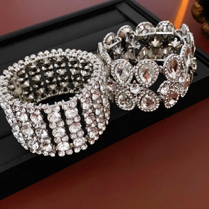 Vue macro d'un large bracelet en goutte ajourée avec strass sur plateau noir