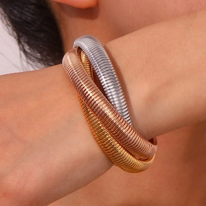 Close-up of triple-strand flexible snake chain bracelet in gold, silver, and rose gold