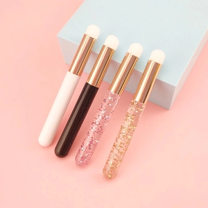 Mini round head lip brushes in four handle styles on blue podium with pink background