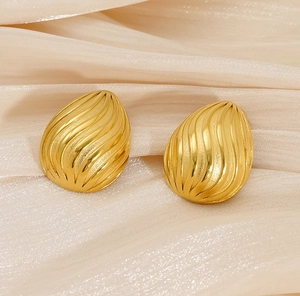 Detailed view of 18K gold plated teardrop earrings with wavy texture on silk fabric