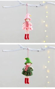 Close-up of plush Christmas elf ornaments with striped scarves hanging on a white branch