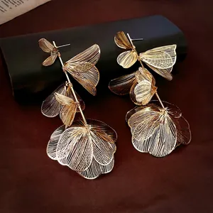 Golden hollow flower tassel earrings with multilayered metallic petals in luxury style