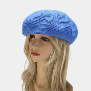 Detail of blue wool knit beret showing textured wave pattern on a female model