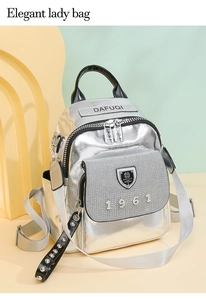 Detail of silver rhinestone backpack featuring DAFUQI letter logo and 1961 emblem